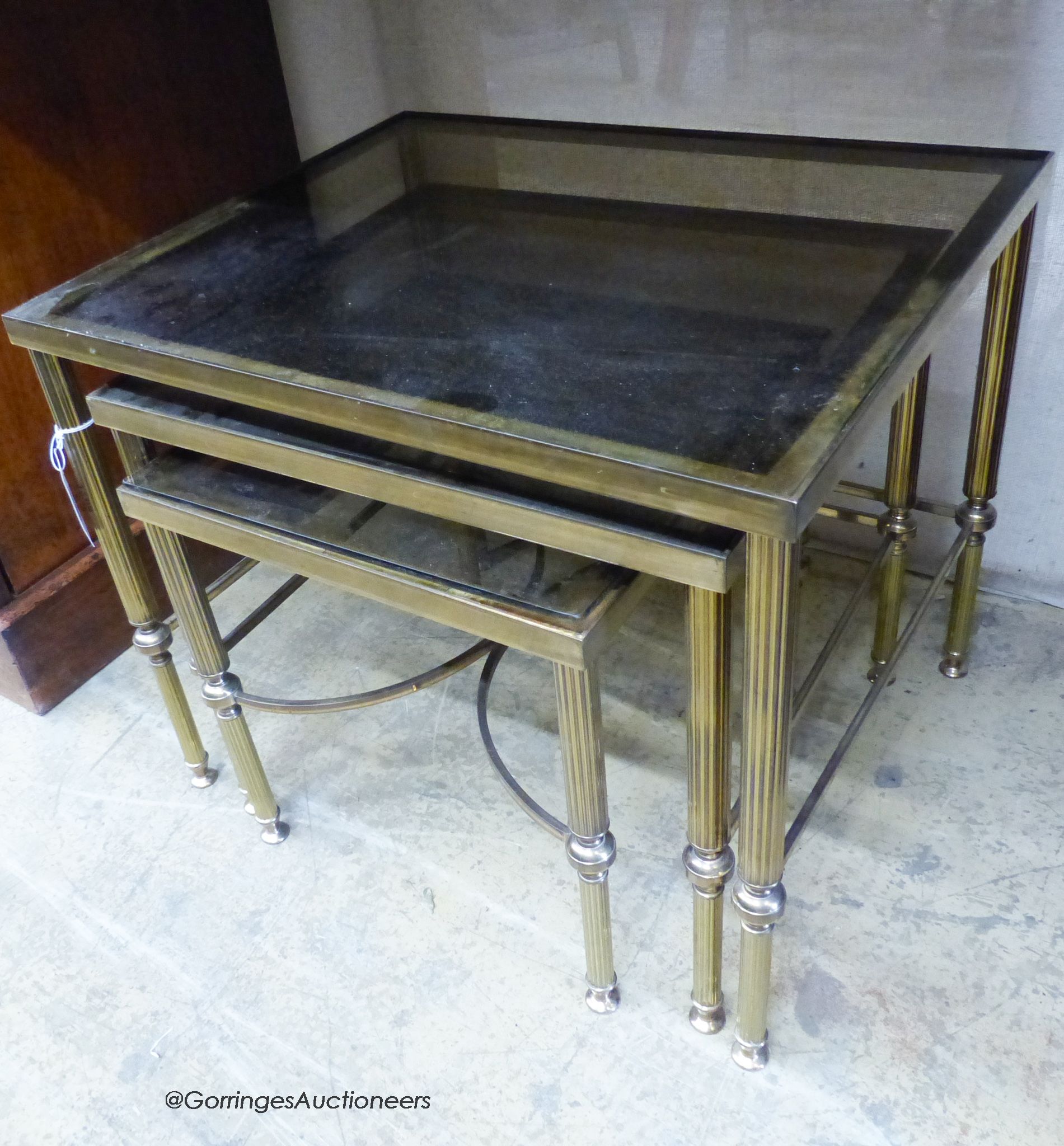 A nest of three brass and glass top tables. W-56cm, D-46cm, H-46cm.